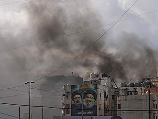 Portraits of Hezbollah's late leaders Hassan Nasrallah, right, and his cousin, Hashem Safieddine, are seen, as smoke rises following an Israeli airstrike in Dahiyeh, Beirut's southern suburbs, Lebanon, Monday, March 30, 2026. 