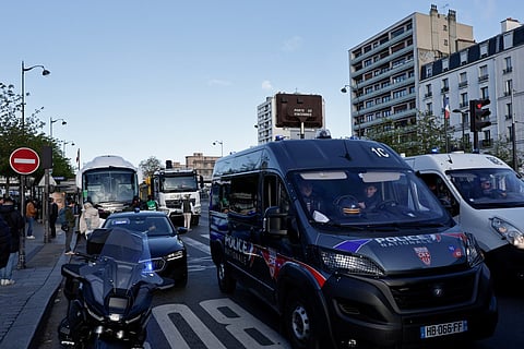 A photo shows parked buses and trucks near police vehicles ahead of a demonstration by lorry and coach drivers to block the city's Boulevard Peripherique ring road, in eastern Paris, on March 30, 2026.