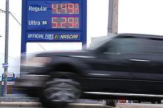 A vehicle passes a gasoline price board at a filling station in Philadelphia, Friday, March 27, 2026. 