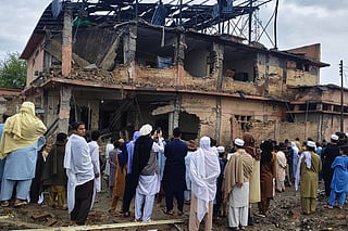 Local residents look at the damaged portion of a police station at the site of an overnight suicide bombing, in Bannu, a district of northwestern Pakistan, Friday, April 3, 2026. (AP Photo/Amaad Khattak)