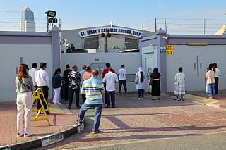 Worshippers pray outside St. Mary's Catholic Church in Oud Metha as parishes across the emirate announce temporary closures