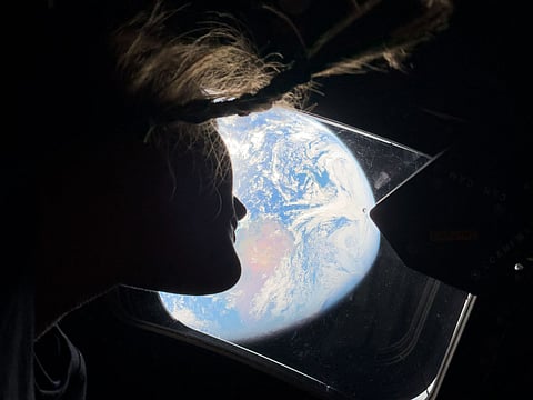 This handout picture by an Artemis II crew member provided by NASA shows Artemis II mission specialist Christina Koch looking back at earth through the window of the Orion spacecraft on April 2, 2026.
