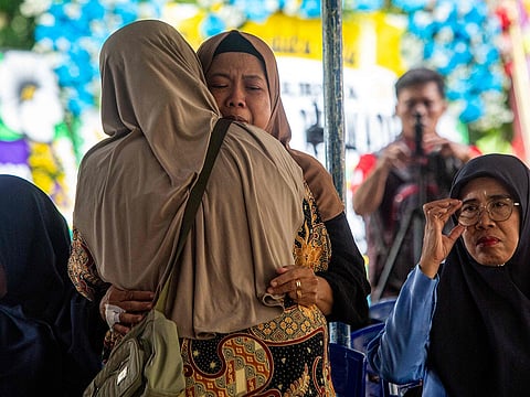 Supinah (centre R), mother of Indonesian soldier Farizal Rhomadhon, a United Nations Interim Force in Lebanon (UNIFIL) personnel who was killed in an artillery attack in Lebanon, is comforted a day after his death at her home in Kulon Progo, Yogyakarta.