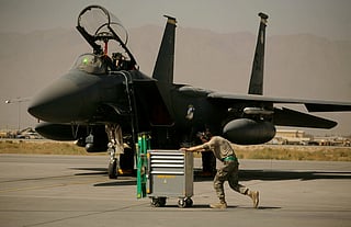 FILE - A U.S. Air Force airman pushes a cart past an F-15E Strike Eagle at Bagram Air Field in Afghanistan on Oct. 17, 2009. (AP Photo/Maya Alleruzzo, File)