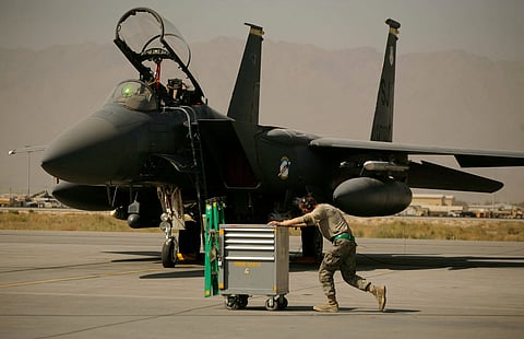 FILE - A U.S. Air Force airman pushes a cart past an F-15E Strike Eagle at Bagram Air Field in Afghanistan on Oct. 17, 2009. (AP Photo/Maya Alleruzzo, File)