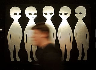 FILE - A patron passes a painting inside the International UFO Museum and Research Center in Roswell, N.M., on June 10, 1997. (AP Photo/Eric Draper, File)
