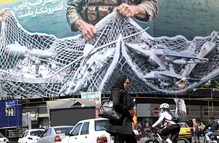 An anti-US billboard depicting American aircraft being caught by Iranian armed forces in a fishing net beneath the words in Farsi, "The Strait of Hormuz will remain closed..." in Tehran. 