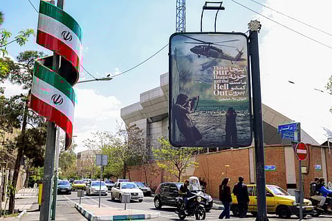 An anti-US banner depicting a helicopter being fired upon is displayed along a street in Tehran on April 6, 2026.
