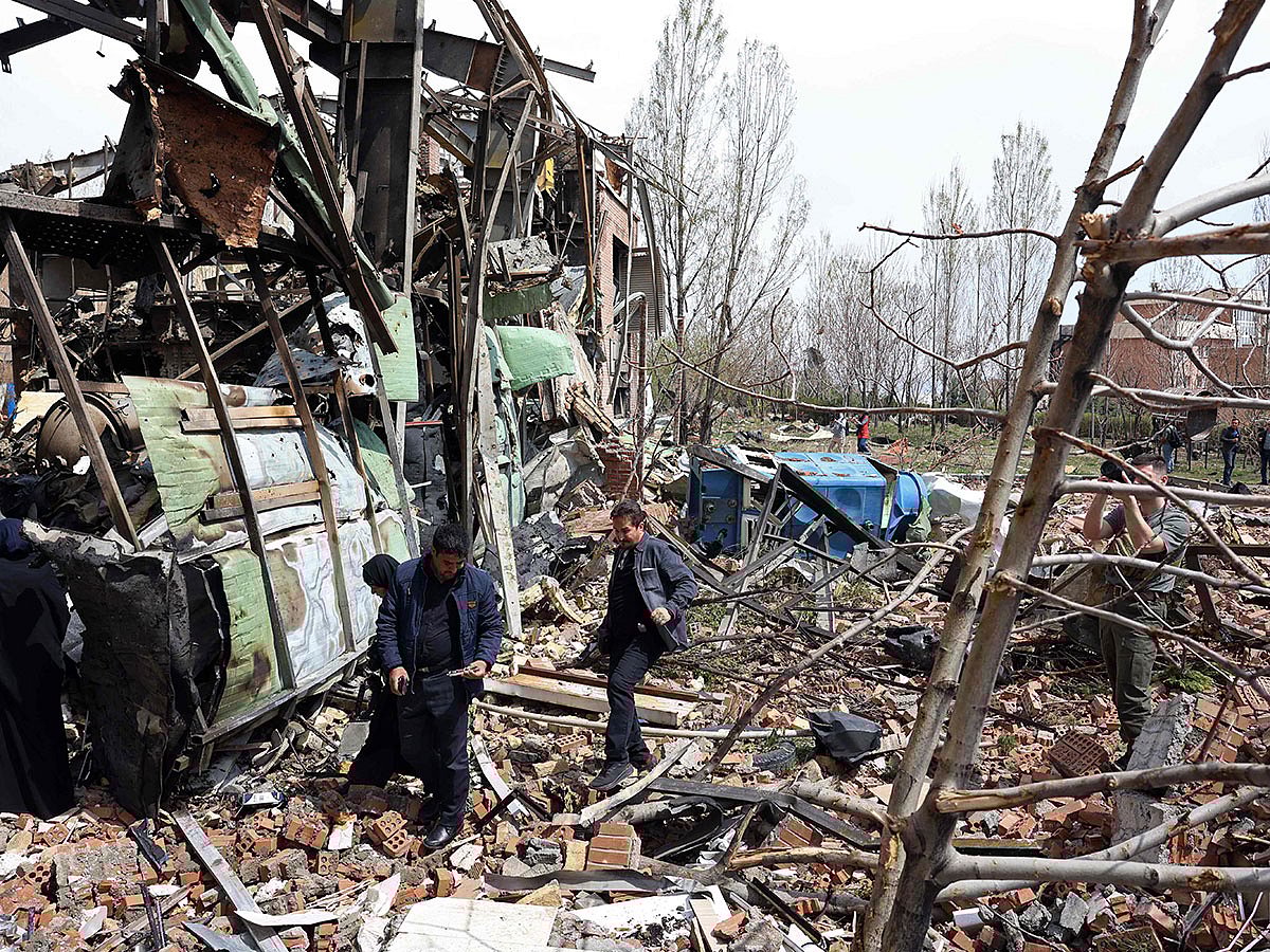 Officials and media representatives gather around the damaged building of the Shahid Beheshti University following a strike, in Tehran on April 4, 2026.
