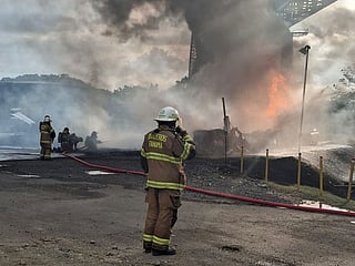 Panamanian firefighters tackling a blaze caused by the explosion of a fuel tanker under the Bridge of the Americas, at the Pacific entrance to the Panama Canal.