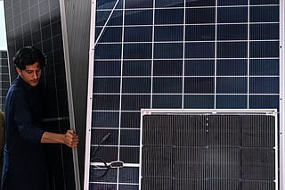 This photograph taken on April 4, 2026 shows a worker arranging solar panels at an electrical appliance store in Rawalpindi as Pakistan faces energy supply chain disruptions amid the Middle East war.