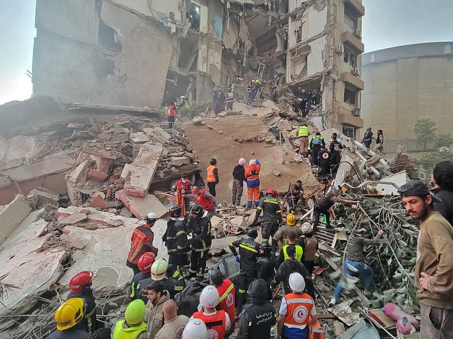 First responders and residents gather at the site of an Israeli airstrike in Beirut's Tallet al-Khayyat neighbourhood, on April 8, 2026.