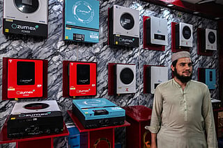 This photograph taken on April 4, 2026 shows a customer shopping for solar inverters at an electrical appliance store in Rawalpindi as Pakistan faces energy supply chain disruptions amid the Middle East war.