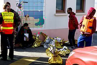A man sits next to rescue units after an attempt to cross the English Channel illegally turned tragic with several migrants found in cardiac arrest, in France's Pas-de-Calais northern coastal city of Equihen-Plage on April 9, 2026.