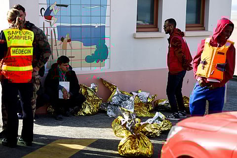 A man sits next to rescue units after an attempt to cross the English Channel illegally turned tragic with several migrants found in cardiac arrest, in France's Pas-de-Calais northern coastal city of Equihen-Plage on April 9, 2026.