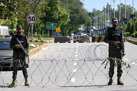 Security personnel stand guard along a street near the expected venue of the US-Iran talks in the Red Zone area of Islamabad on April 10, 2026.