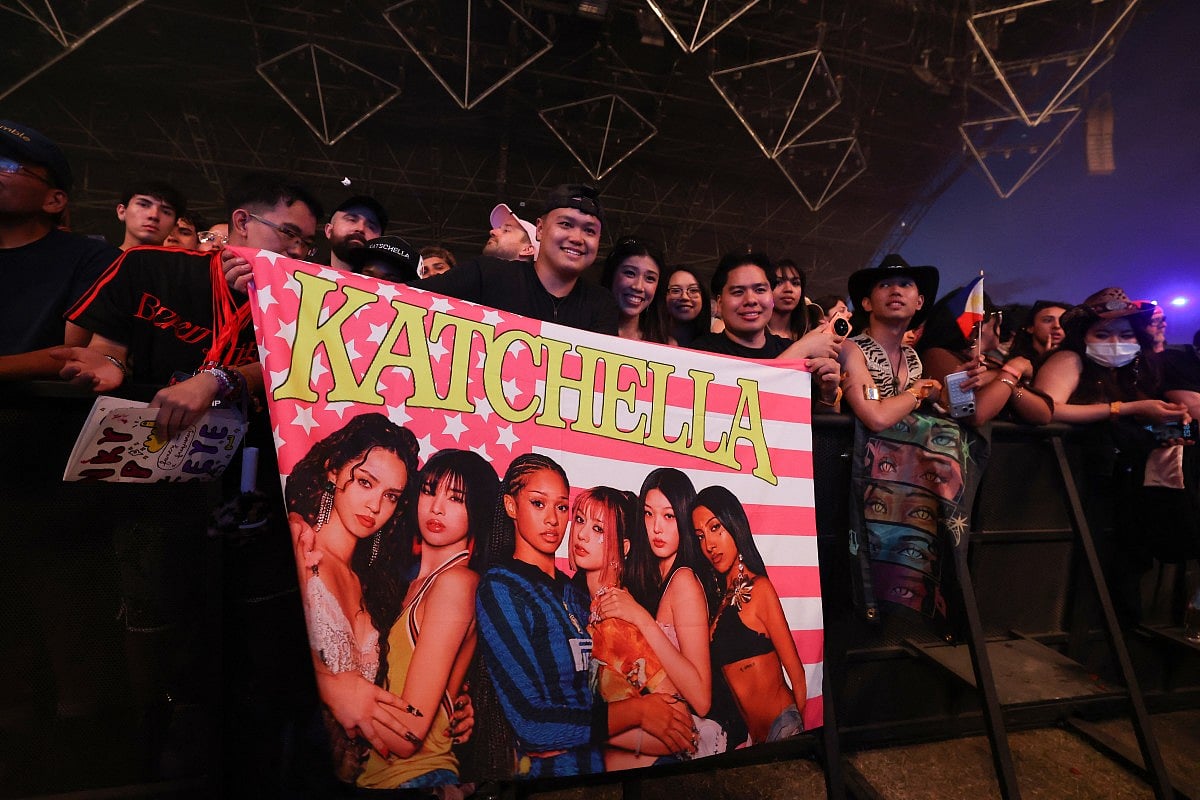 Fans hold a flag as the girl group Katseye performs during the 2026 Coachella Valley Music and Arts Festival at the Empire Polo Club in Indio, California on April 10, 2026.