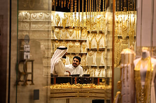 Emirati gold dealers are pictured in a shop in the Dubai Gold Souk on April 13, 2025.