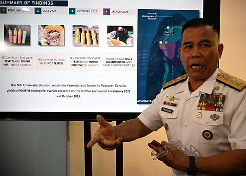 Philippine Navy spokesman Rear Admiral Roy Vincent Trinidad speaks next to a slide presentation of seized yellow bottles suspected to contain cyanide in waters of Second Thomas Shoal in the disputed South China Sea