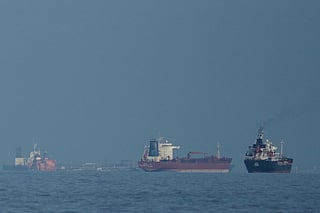 FILE - Oil tankers and cargo ships line up in the Strait of Hormuz as seen from Khor Fakkan, United Arab Emirates, Wednesday, March 11, 2026. (AP Photo/Altaf Qadri,File)