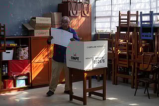 A voter looks at a ballot before marking his candidates during general elections in Lima, Peru, on Sunday, April 12, 2026. (AP Photo/Martin Mejia)