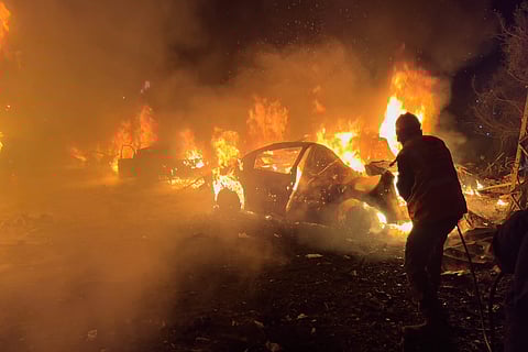 A firefighter extinguishes a car at the site of Israeli airstrikes, in Beirut, Lebanon, Wednesday, April 1, 2026. 