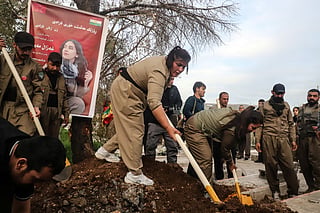 Female members of the Iranian Kurdish opposition Komala party attend to the grave of Ghazal Moulai, a Peshmerga fighter in the ranks of the Iranian Kurdish opposition, during her funeral at the "Sheikh Ahmed Hindi" cemetery in the city of Sulaymaniyah, in the autonomous Kurdistan region on April 16, 2026.
