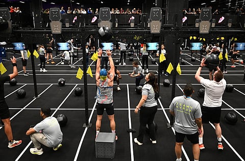 Visitors perform during indoor fitness competition Hyrox event at the FIBO trade show for health, fitness and wellness in Cologne, western Germany on April 16, 2026.