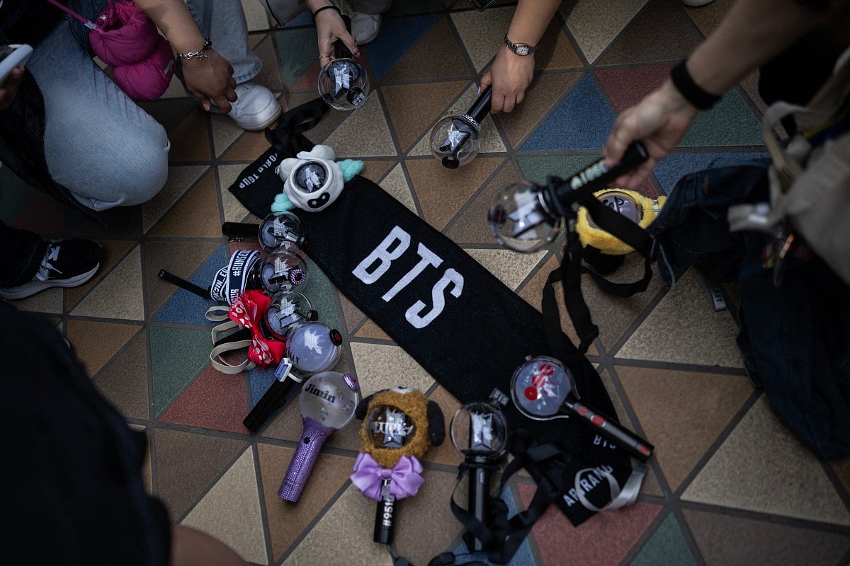 Fans of Korean boy band BTS put down their glow sticks next to a banner as they wait in line at Tokyo Dome before the start of the first BTS World Tour ‘Arirang’ in Tokyo on April 17, 2026.
