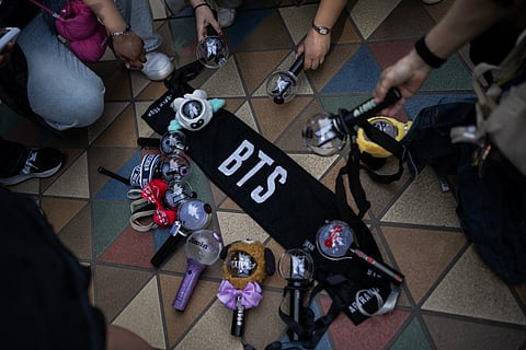Fans of Korean boy band BTS put down their glow sticks next to a banner as they wait in line at Tokyo Dome before the start of the first BTS World Tour ‘Arirang’ in Tokyo on April 17, 2026.
