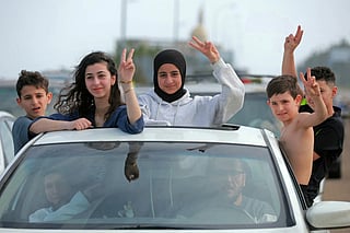 Displaced residents travel through the Qasmieh area as they flash victory signs on the way back to their homes in the southern Lebanon, on April 17, 2026.