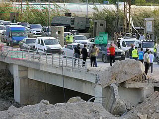 Displaced residents travel back to their homes past the ongoing restoration work at the site of Israeli strikes that targeted the Qasmieh bridge built over the Litani river in the southern Lebanese area of Al Qasmiyeh on April 17, 2026. 