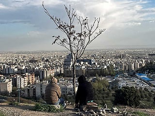People sit overlooking the city at Pardisan Park in Tehran. 