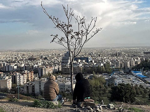 People sit overlooking the city at Pardisan Park in Tehran. 