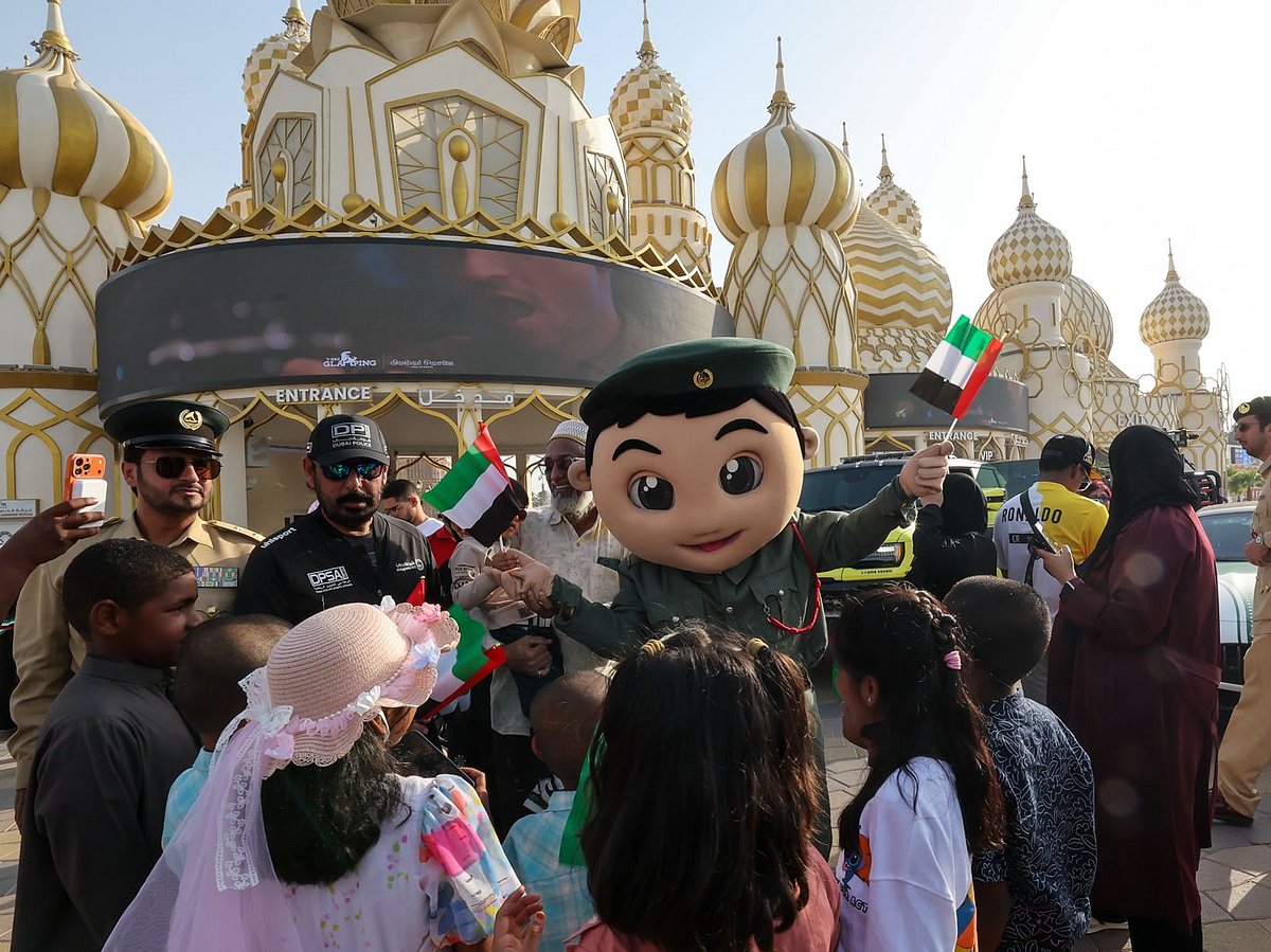 A Dubai police mascot with kids at season 30 of Global Village which reopened after a month-long pause.  