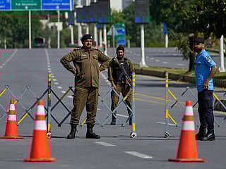 Police officers stand guard at a checkpoint ahead of the second round of negotiations between the U.S. and Iran, in Islamabad, Pakistan.