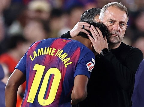 Barcelona's German coach Hans-Dieter Flick hugs Lamine Yamal as he is substituted due to injury