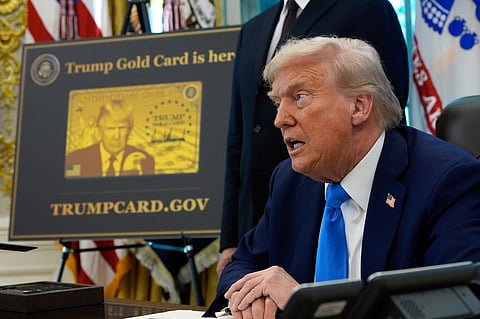 FILE - A poster showing the Trump Gold Card is seen as President Donald Trump signs executive orders in the Oval Office of the White House, Sept. 19, 2025, in Washington. (AP Photo/Alex Brandon, File)