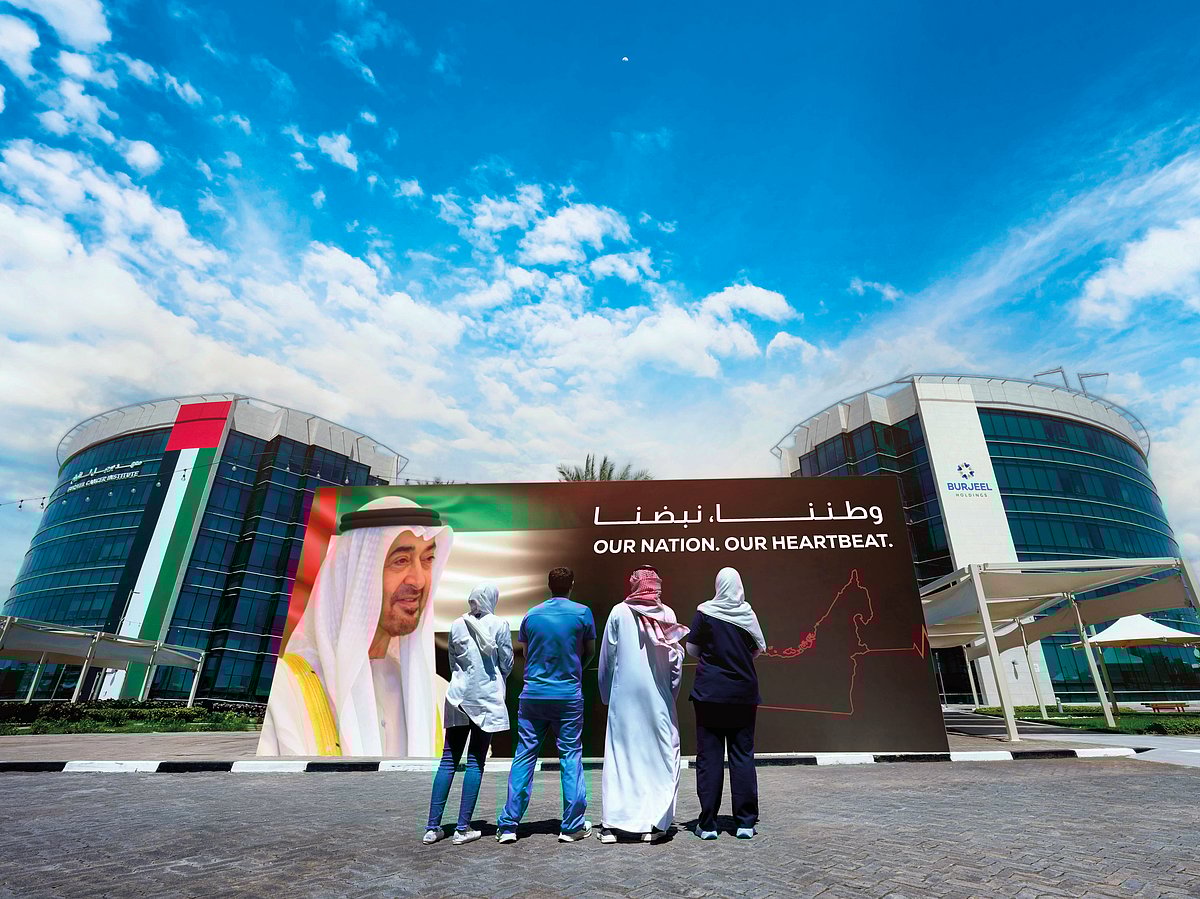 In solidarity with the UAE, frontline workers of Burjeel Holdings stand outside Burjeel Medical City, looking at a photo of UAE President His Highness Sheikh Mohamed bin Zayed Al Nahyan