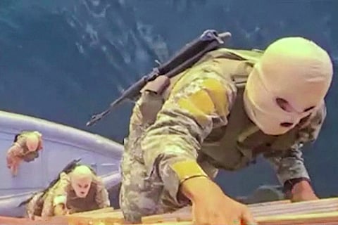 This screen grab from video released by Iran’s Revolutionary Guards (IRGC) and aired by state broadcaster IRIB on April 23, 2026, allegedly shows IRGC naval forces boarding a ship in the Strait of Hormuz.