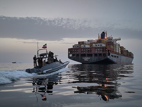 In this photo released by Tasnim News Agency, a Revolutionary Guard Navy (IRGC) speedboat approaches the cargo ship Epaminondas during what state media described as the seizure of one of two vessels accused of violations in the Strait of Hormuz, April 21, 2026. 