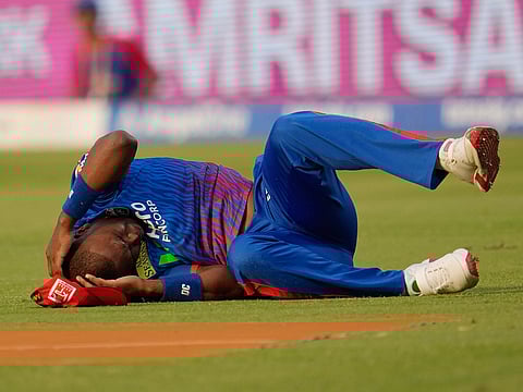 Delhi Capitals' Lungi Ngidi writhes in pain on the ground after attempting to take a catch during the IPL 2026 match against Punjab Kings in New Delhi, on Saturday, April 25, 2026.