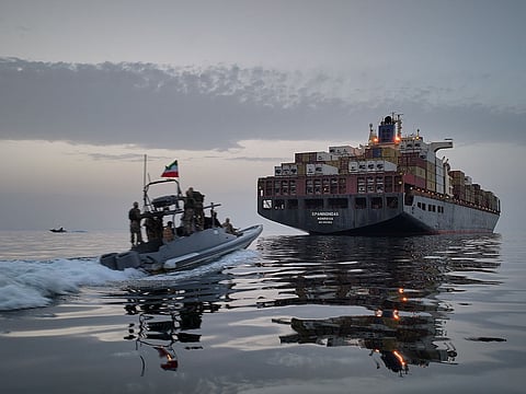 In this photo released by Tasnim News Agency, a Revolutionary Guard Navy (IRGC) speedboat approaches the cargo ship during what state media described as the seizure of one of two vessels accused of violations in the Strait of Hormuz