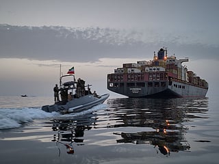 In this photo released by Tasnim News Agency, a Revolutionary Guard Navy (IRGC) speedboat approaches the cargo ship Epaminondas during what state media described as the seizure of one of two vessels accused of violations in the Strait of Hormuz