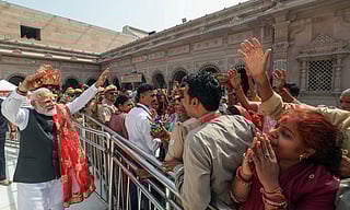 Prime Minister Narendra Modi greets the devotees as he visits the Shri Kashi Vishwanath temple, in Varanasi on Wednesday. 