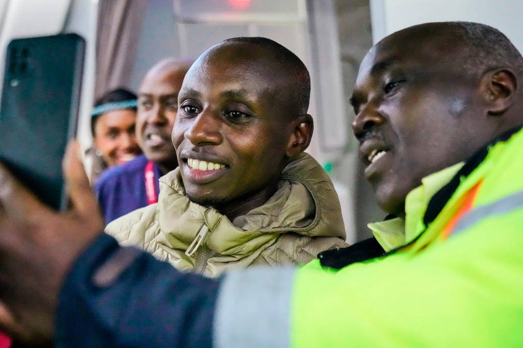 Sabastian Sawe poses for a selfie with an airport worker after arriving on a plane from London, Wednesday, April 29, 2026, at Jomo Kenyatta International Airport in Nairobi, Kenya, after setting a new world record in the marathon. (AP Photo/Brian Inganga) CORRECTION: Corrects spelling of first name to Sabastian, not Sebastian