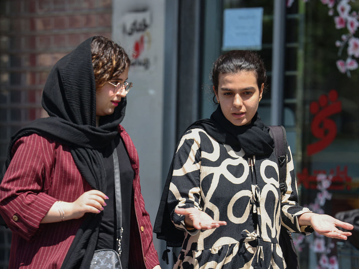 Iranian women walk at the Revolution Square in Tehran. 
