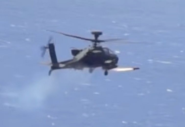 An Apache attack helicopter fires a "Hellfire" missile on a target. 