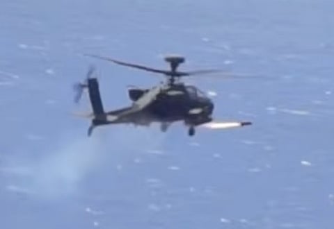An Apache attack helicopter fires a "Hellfire" missile on a target. 