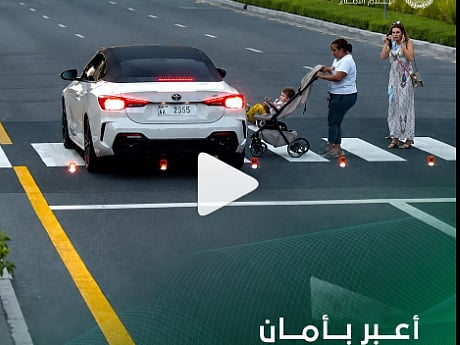 A video released by Dubai Police shows a dangerous near-miss at a pedestrian crossing where a child in a stroller narrowly avoided being hit, highlighting road safety concerns.